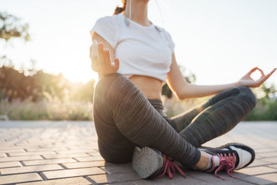 Low section of woman sitting outdoors