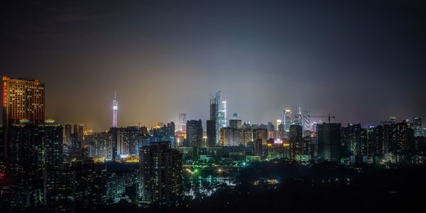 Panoramic view of illuminated cityscape against sky at night