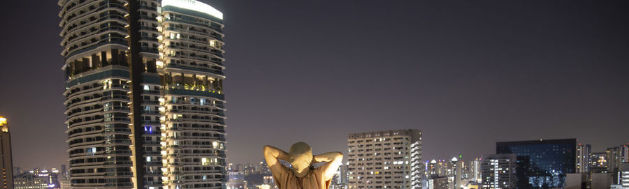 Low angle view of illuminated buildings against sky at night