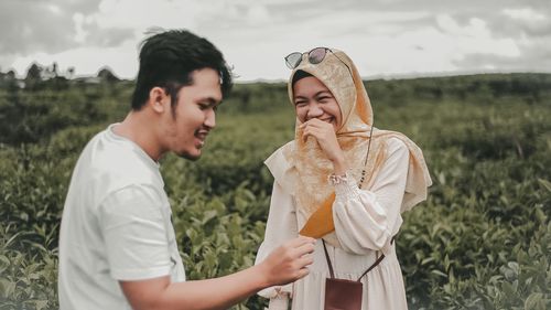 Young couple standing on field