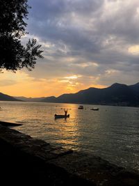 Scenic view of boat in river against cloudy sky