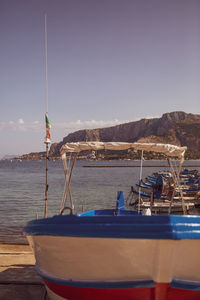 Sailboats moored on sea against clear sky