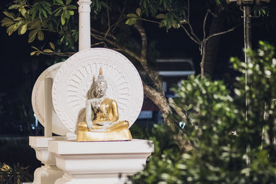 Statue of buddha against trees