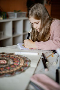 Girl drawing on paper at home