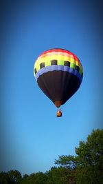 Low angle view of hot air balloon against clear blue sky