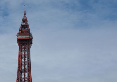 Low angle view of flag on top of tower against sky