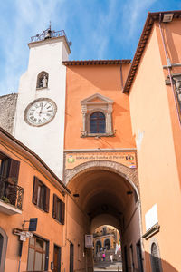 Low angle view of clock tower amidst buildings in city