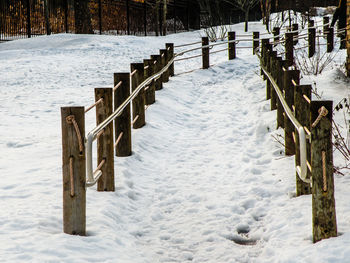 Wooden posts on snow covered field