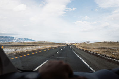 Road passing through landscape against sky