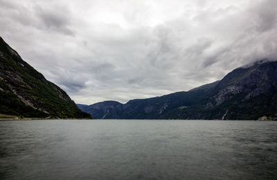 Scenic view of sea and mountains against sky