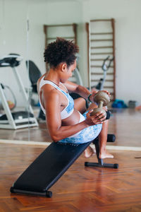 Young woman lifting dumbbell at gym