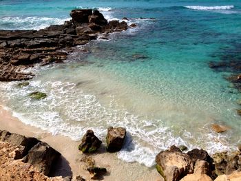 High angle view of rocks on sea shore