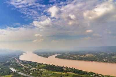 Aerial view of city and river against sky