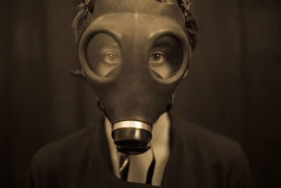 Close-up portrait of young woman wearing gas mask