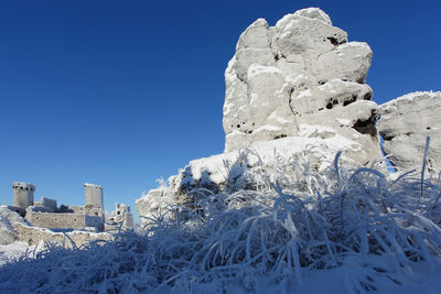 Low angle view of snow against clear blue sky