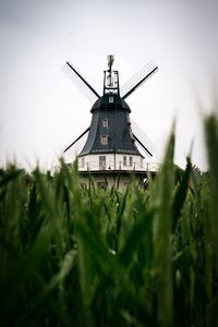 Traditional windmill on field against sky