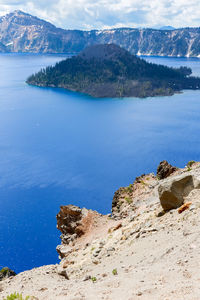 Scenic view of sea and mountains against sky