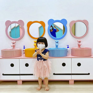 Little girl likes colourful washing basins 