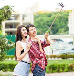 Portrait of happy young couple holding camera