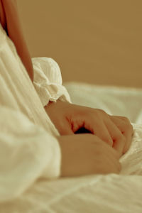 Low section of woman relaxing on bed at home