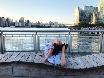 Girl exercising on bench in city