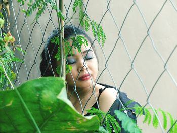 Young woman leaning against fence