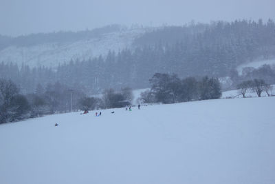 Panoramic view of people on snow covered landscape