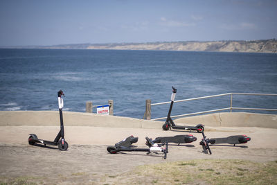 Four abandoned electric scooters, la jolla cove overlooking ocean