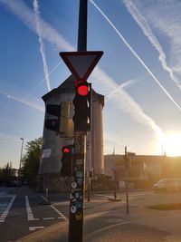 Road sign on street against sky in city