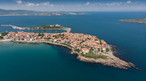 High angle view of land and blue sea against sky