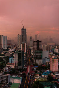 Aerial view of buildings in city against sky during sunset