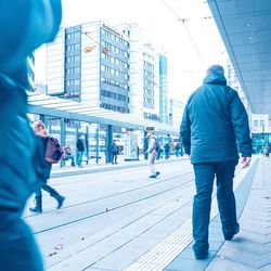 Rear view of people walking on street in city