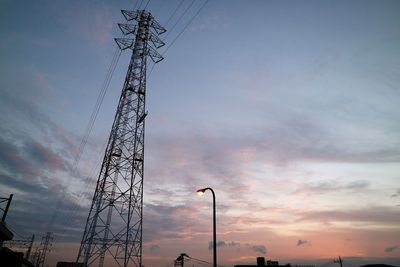 Low angle view of silhouette electricity pylon against sky during sunset