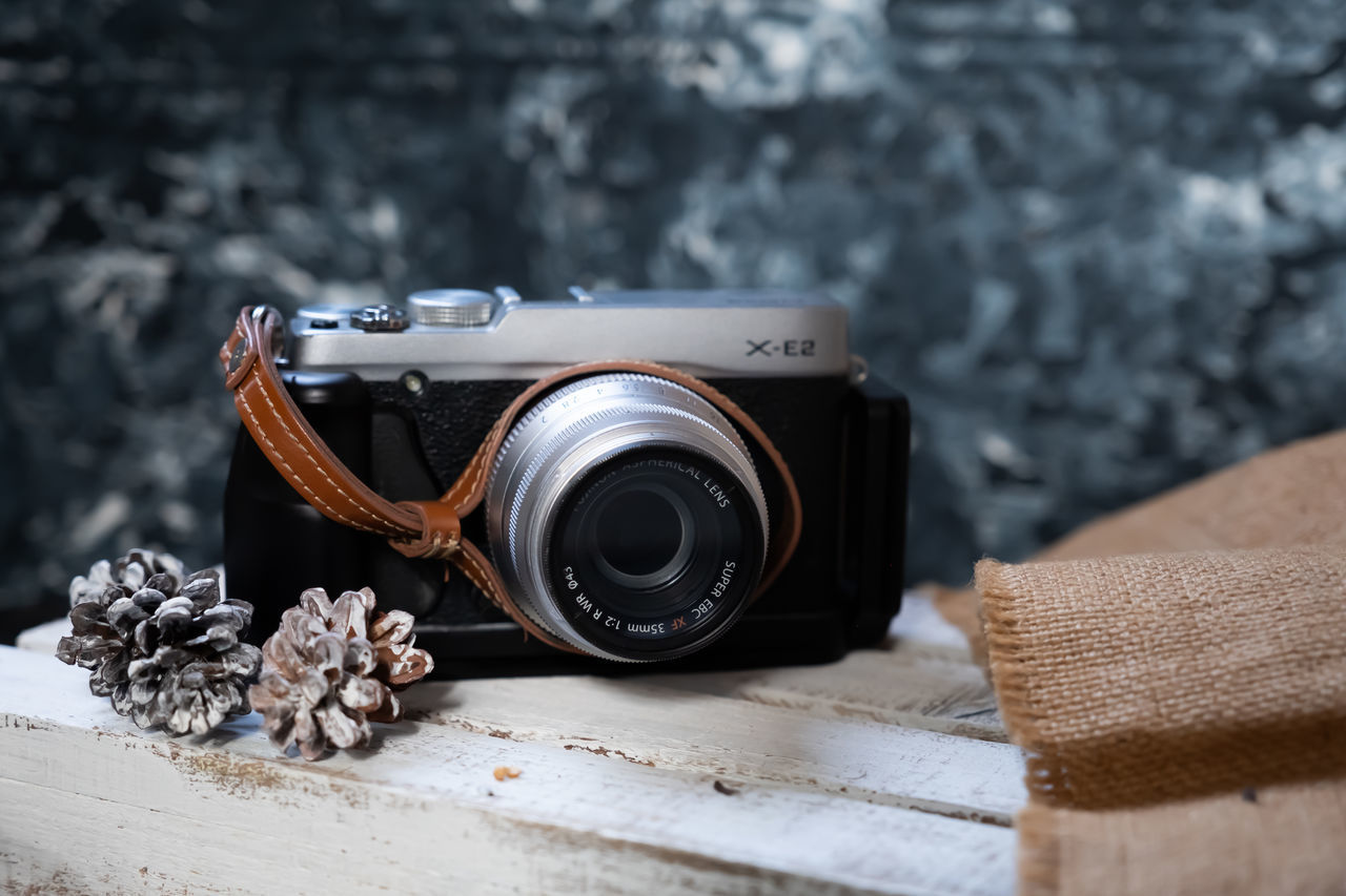 CLOSE-UP OF VINTAGE CAMERA ON TABLE AT HOME