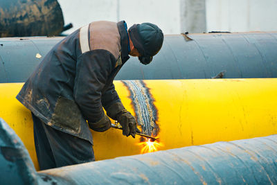 Side view of man working on motorcycle