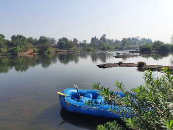 Boats moored in lake against sky