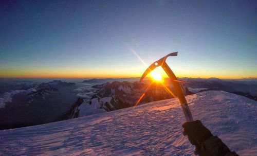 Scenic view of snowcapped mountains against clear sky during sunset