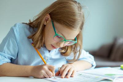 Close-up of girl writing in book