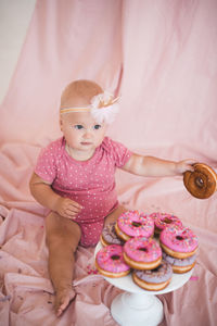 Cute girl holding sweet food at home