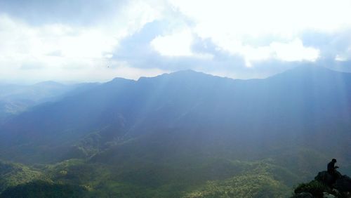 Scenic view of mountains against cloudy sky