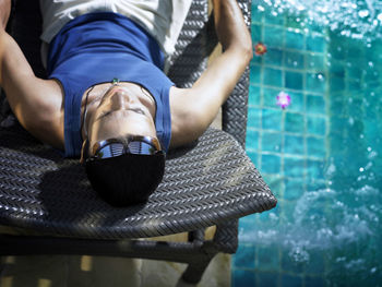 Man relaxing on chair at poolside