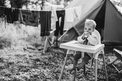Rear view of woman sitting on field