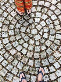 Low section of people standing on cobbled street