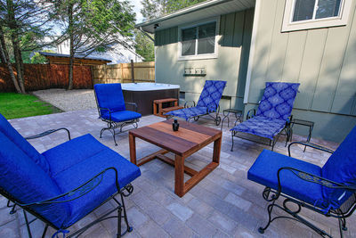 Empty chairs and table against building