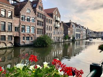 Canal amidst buildings in city against sky