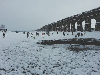 People on snow covered mountain against sky