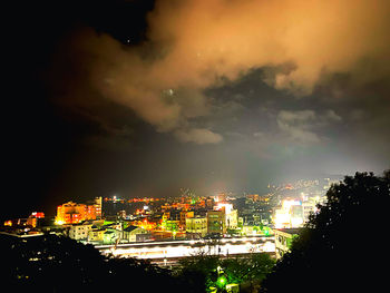 High angle view of illuminated cityscape against sky at night