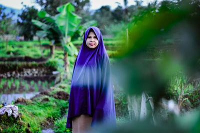 Portrait of woman standing against plants