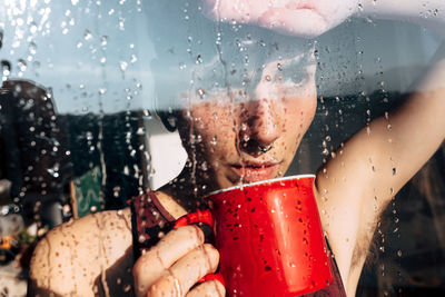 Thoughtful woman drinking coffee near window