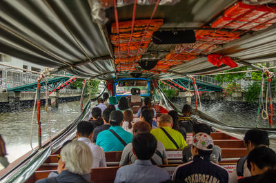 Rear view of people sitting in boat